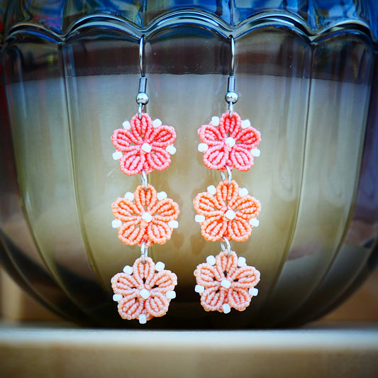Boucles d’oreilles Blossom avec trois fleurs tissées en micro-macramé en camaïeu de couleur Corail, création artisanale Macram’Elo Créations.