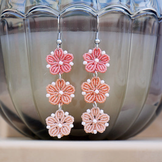Boucles d’oreilles Blossom avec trois fleurs tissées en micro-macramé en camaïeu de couleur Corail, création artisanale Macram’Elo Créations.