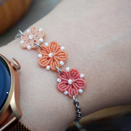 Bracelet Blossom orné de trois fleurs en micro-macramé en camaïeu de Corail sur chaîne perlée argentée, bijou fleuri fait main par Macram’Elo Créations.