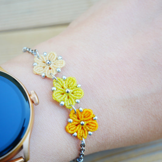 Bracelet Blossom orné de trois fleurs en micro-macramé en camaïeu de Jaune sur chaîne perlée argentée, bijou fleuri fait main par Macram’Elo Créations.