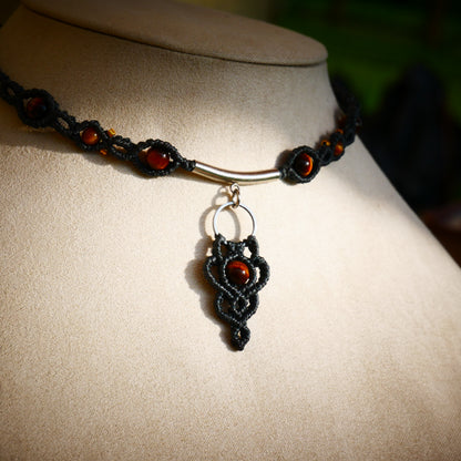 Pendentif central en micro-macramé sombre orné d'une perle d'œil de tigre