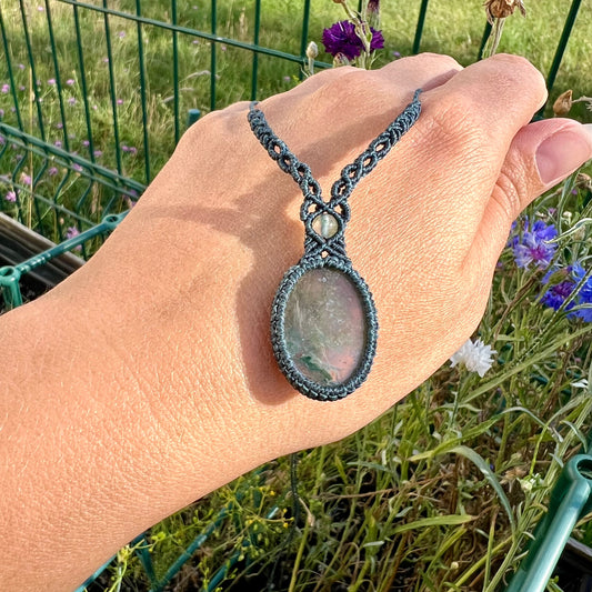 Un collier tissé en micro-macramé gris foncé avec un cabochon oval et une perle une pierre naturelle d'Agate mousse