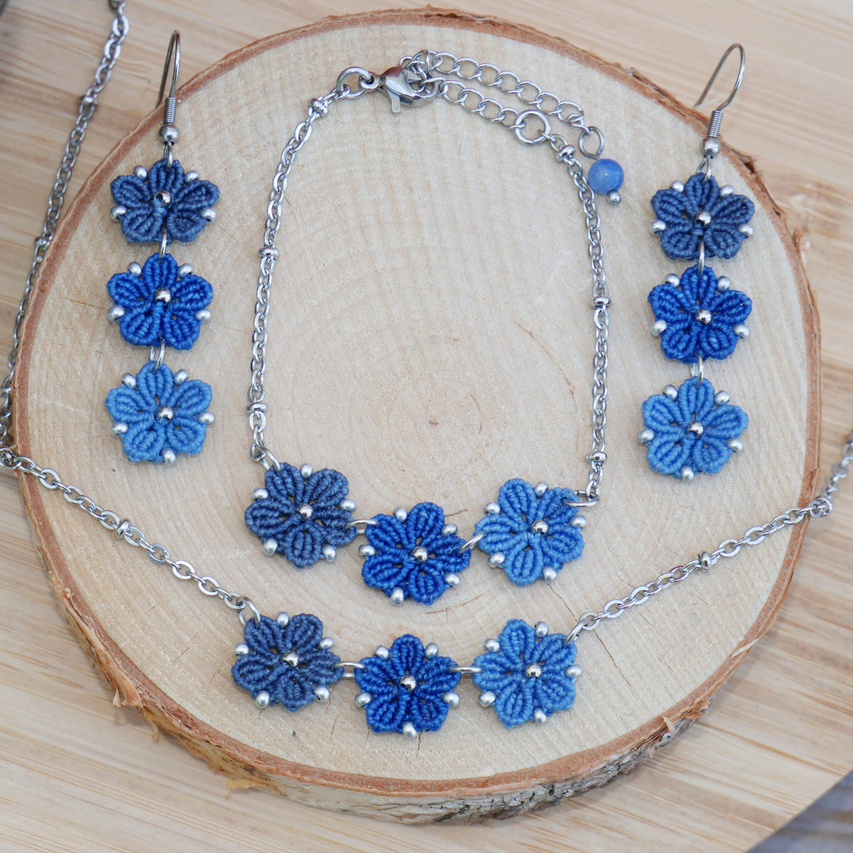 Parure Blossom avec trois fleurs en micro-macramé en camaïeu de couleur Bleu sur chaîne perlée argentée, bijou artisanal floral Macram’Elo Créations.